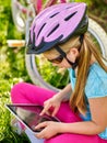 Bicycle girl wearing helmet watching at tablet pc in cycling. Royalty Free Stock Photo