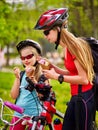 Bicycle girls with rucksack eating ice cream cone in park. Royalty Free Stock Photo