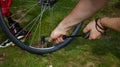 Young man`s hands pumping air into bicycle tyre using hand pump - image Royalty Free Stock Photo