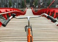 Bicycle handlebar POV view. Orange bike on the wooden red Python bridge in Amsterdam, Netherlands Royalty Free Stock Photo