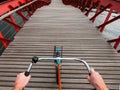 Bicycle handlebar POV view. Orange bike on the wooden red Python bridge in Amsterdam, Netherlands