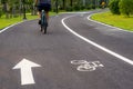 Bicycle lane marking or bike road sign with an arrow on the street in the public park Royalty Free Stock Photo