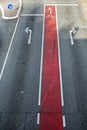 Bicycle lane with red marking and bike symbol on the asphalt road with directional arrows, background texture Royalty Free Stock Photo