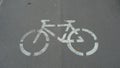 Bicycle lane sign on asphalt surface. Grey road and white painted sign Royalty Free Stock Photo