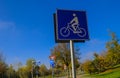 Bicycle lane sign close-up across other road signs, trees and blue sky. Transportation. cycling