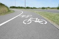 Bicycle lane with white sign painted on asphalt near sidewalk Royalty Free Stock Photo
