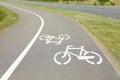 Bicycle lane with white sign painted on asphalt near sidewalk Royalty Free Stock Photo