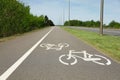 Bicycle lane with white sign painted on asphalt near sidewalk Royalty Free Stock Photo