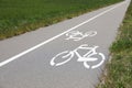 Bicycle lane with white sign painted on asphalt near sidewalk Royalty Free Stock Photo