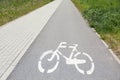 Bicycle lane with white sign painted on asphalt near sidewalk Royalty Free Stock Photo