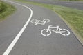 Bicycle lane with white sign painted on asphalt near sidewalk Royalty Free Stock Photo