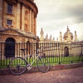 The bicycle is leaning against the fence. In the background, the buildings of the University of Oxford. University city in England Royalty Free Stock Photo