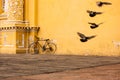 Bicycle Leaning Against Yellow Wall