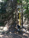 Bicycle leaning on a yellow direction sign in a hiking area