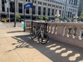 Bicycle locked up on LaSalle Stree near Chicago River is casting shadows onto sidewalk