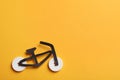 Bicycle made with buttons and black cutout on orange background, flat lay. Space for text