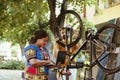 Bicycle maintenance with laptop in yard Royalty Free Stock Photo