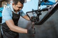 a bicycle mechanic uses a manual tool when assembling a bicycle frame