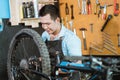 a bicycle mechanic wearing an apron and gloves repairing a mountain bike Royalty Free Stock Photo