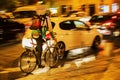 Bicycle messenger in city traffic at night