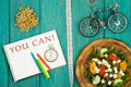 bicycle model, salad of fresh vegetables, notepad with text & x22;YOU CAN!& x22;, stopwatch and tape measure Royalty Free Stock Photo