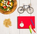 bicycle model, salad of fresh vegetables, red notepad, stopwatch Royalty Free Stock Photo