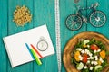 bicycle model, salad of fresh vegetables, red notepad, stopwatch Royalty Free Stock Photo