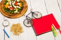 bicycle model, salad of fresh vegetables, red notepad, stopwatch Royalty Free Stock Photo