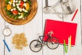 bicycle model, salad of fresh vegetables, red notepad, stopwatch Royalty Free Stock Photo