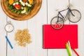 bicycle model, salad of fresh vegetables, red notepad, stopwatch Royalty Free Stock Photo