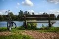 Bicycle near bench and pond in park Royalty Free Stock Photo