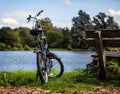 Bicycle near bench and pond in park Royalty Free Stock Photo