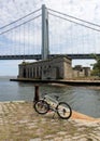 Bicycle on an old stone pier, Battery Weed and Verrazzano Bridge in the background, Staten Island, NY, USA