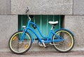 A bicycle parked against the wall of the house, secured by an anti-theft chain to the window bars. Wall, sidewalk. Photo. Royalty Free Stock Photo