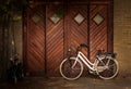 Bicycle parked against wooden garage door