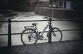 Bicycle parked on bridge over city river, blurry background. Royalty Free Stock Photo