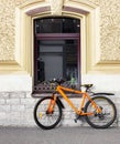 A bicycle parked in front of the building and secured with an anti-theft chain. Window arch, beautiful photo. Royalty Free Stock Photo