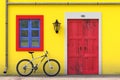 Bicycle Parked in front of Retro Vintage European House Building with Red Door, Blue Window and Yellow Wall, Narrow Street Scene. Royalty Free Stock Photo