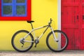 Bicycle Parked in front of Retro Vintage European House Building with Red Door, Blue Window and Yellow Wall, Narrow Street Scene. Royalty Free Stock Photo