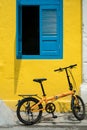 Bicycle parked in front of the shop house with yellow wall and antique blue window Royalty Free Stock Photo
