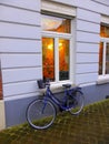 Bicycle parked outside building with coloured window