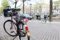 Bicycle parked on the street in the foreground with a typical canal and architecture of Amsterdam, Netherlands Royalty Free Stock Photo