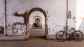 A bicycle parked beside the walls of an old, arched, faded tunnel with diminishing