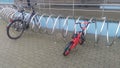 A bicycle parking lot made in the form of a spiral made of chrome-plated metal pipe is installed on the concrete tile sidewalk nea Royalty Free Stock Photo