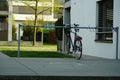 Bicycle parking place for visitors in front of a residential building with a parked bike as an example.