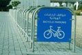 bicycle parking rack in street side with sign board in english and arabic letter