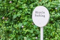 Bicycle parking white sign with fresh natural green tree gardening background in the park information contemporary