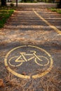 Bicycle path in the autumn park with yellow paint applied to the asphalt Royalty Free Stock Photo