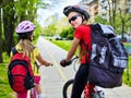 Bicycle path with children. Girls wearing helmet with rucksack ciclyng ride. Royalty Free Stock Photo