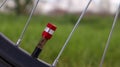 Bicycle red nipple. Detail of a used bicycle rim with valve stem and cover. Mountain bike tire. Bicycle wheel valve. Royalty Free Stock Photo